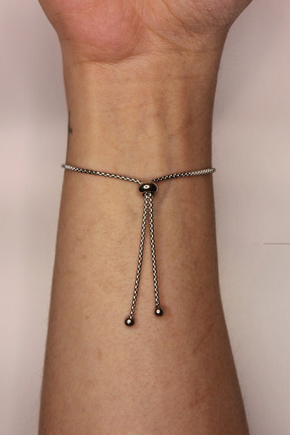 Pulsera plana ajustable con barra de acero inoxidable con corte en cruz.